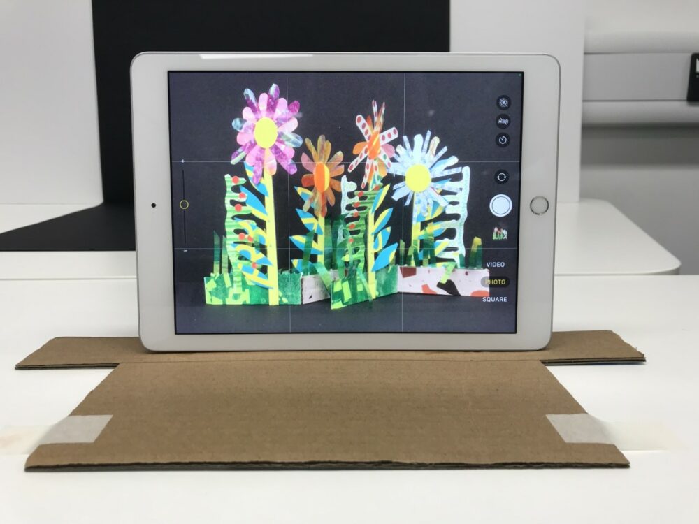 Viewing a flower sculpture through an i pad.