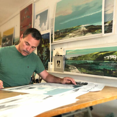 Artist Alej Ez working at his desk.