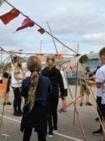 A series of paper shapes attached to bamboo canes like flags.