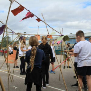 A series of paper shapes attached to bamboo canes like flags.