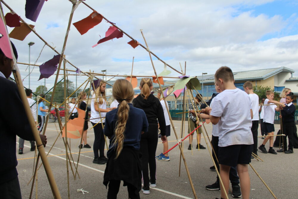 A series of paper shapes attached to bamboo canes like flags.