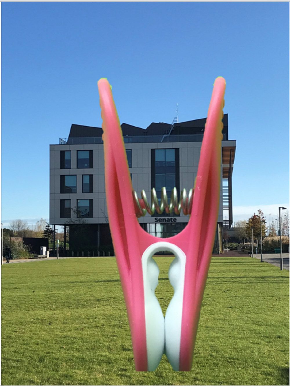 A clothes peg set against a green screen background of a building