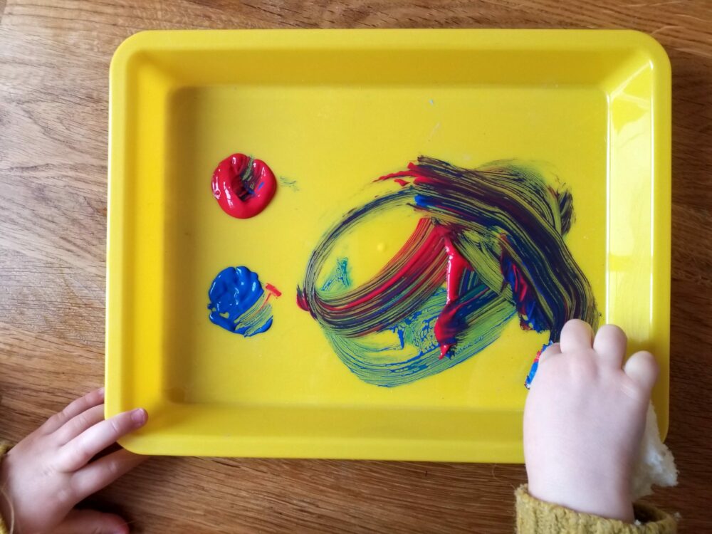 Mixing paints in a tray.
