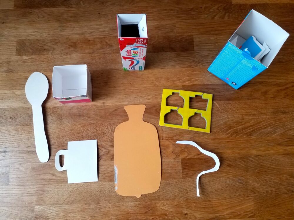 Cut out cardboard items for a magic caring box.