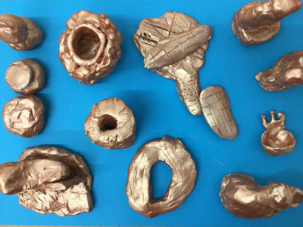 A collection of small sculptures made from clay.