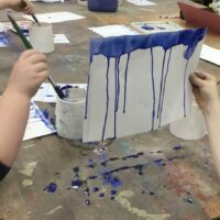 Blue paint dripping down paper.