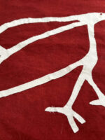 The AccessArt Bird Logo, sewn in white fabric on red cotton