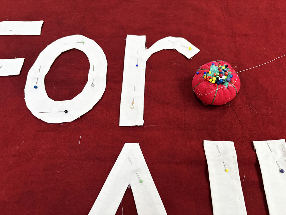 Cloth letters pinned on to the background of a banner