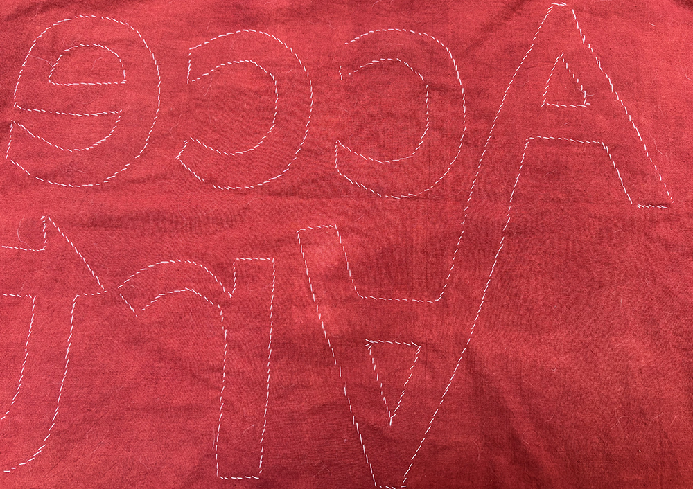 the back of the banner showing stitches attaching the letters