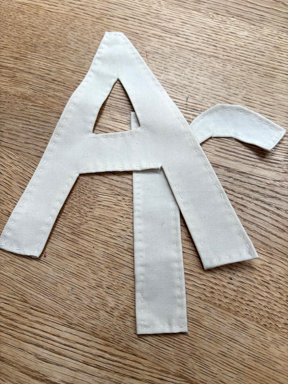 the fabric hemmed over the interfacing to form each letter